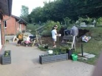 Eltern und Kinder arbeiten gemeinsam im Garten.