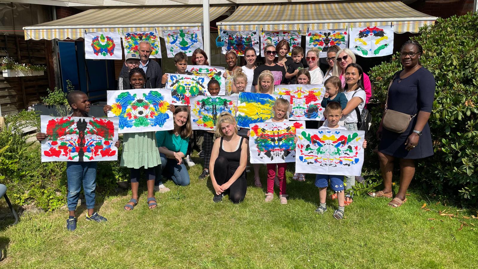 Pressefoto der Stiftung Bildung - Teilnehmende Kinder eines Kunstworkshops halten selbstgemalte Bilder in den Händen